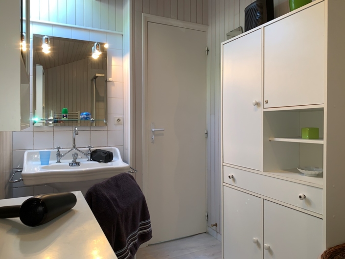 Salle de bain de la location meublé, lavabo et meuble de rangement