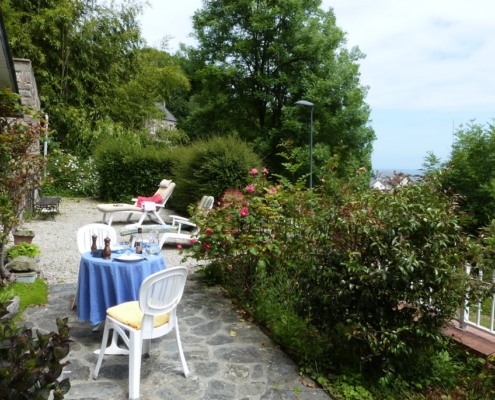 La terrasse du gite l'avenue avec la table du déjeuner, vue sur le mer de la manche et les bains de soleil