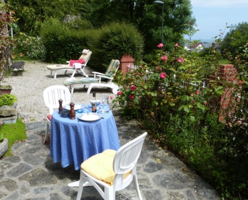 La terrasse du gite l'avenue avec la table du déjeuner, vue sur le mer de la manche et les bains de soleil