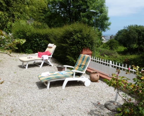 La terrasse du gite l'avenue avec la table du déjeuner, vue sur le mer de la manche et les bains de soleil